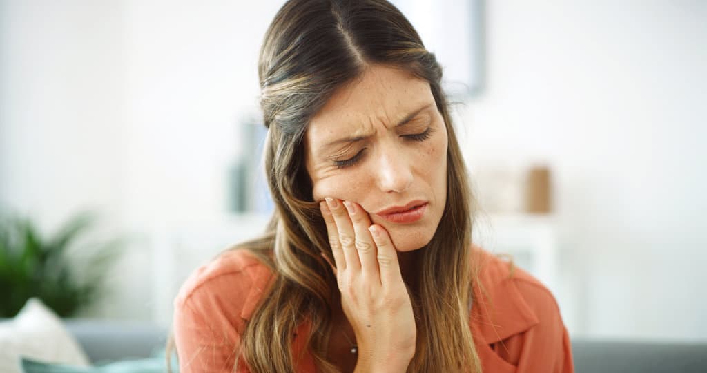 Woman, sore mouth and toothache at house from dental cavity, tooth extraction and gum infection. Female person, discomfort and oral decay with gingivitis, root canal injury and treatment for filling