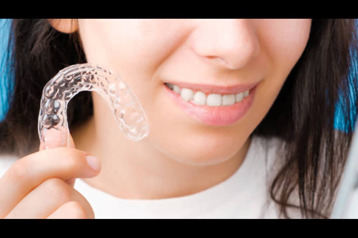 Smiling Woman Holds Transparent Plastic Mouth Guard.jpg