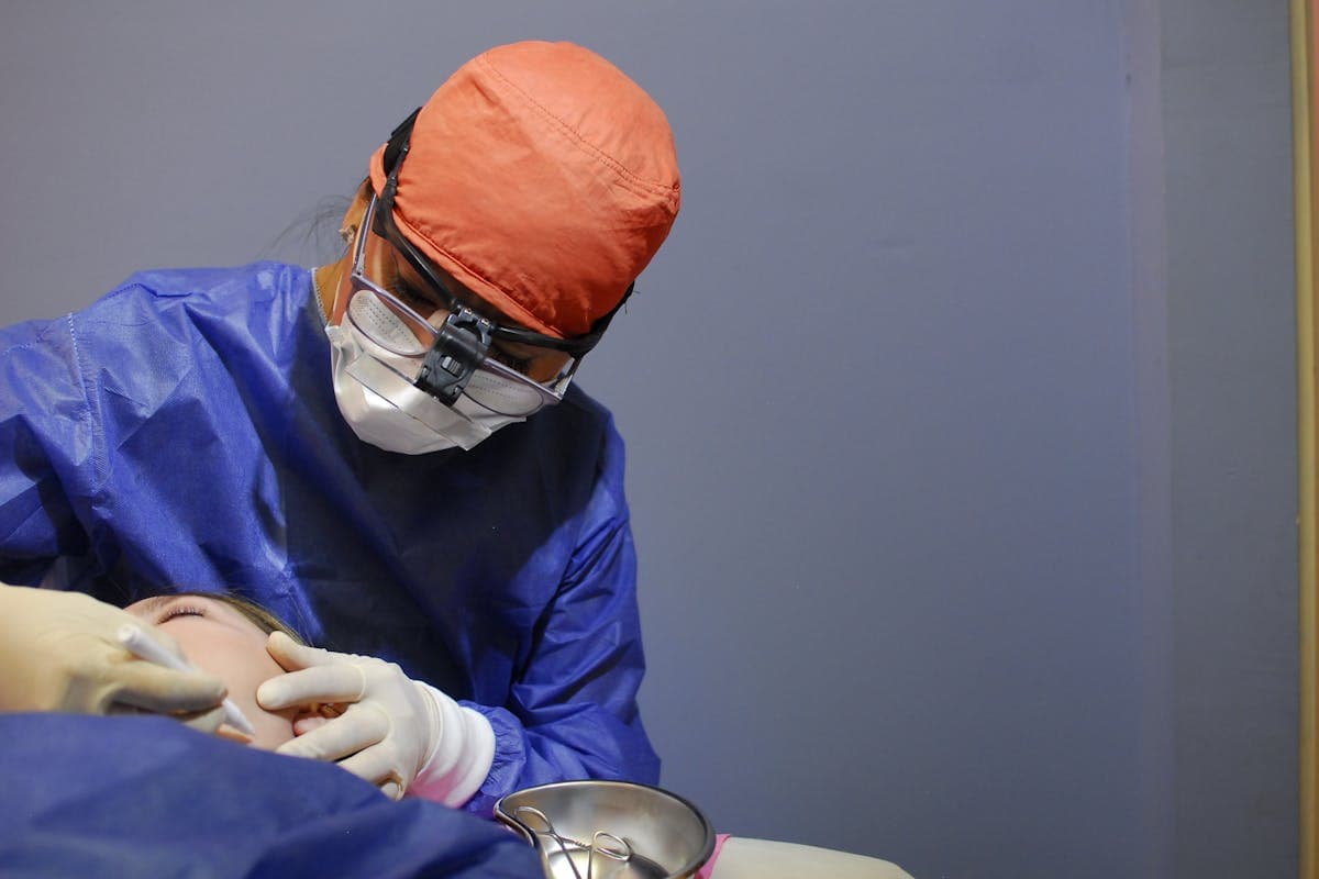 Dentist in protective gear performing a procedure