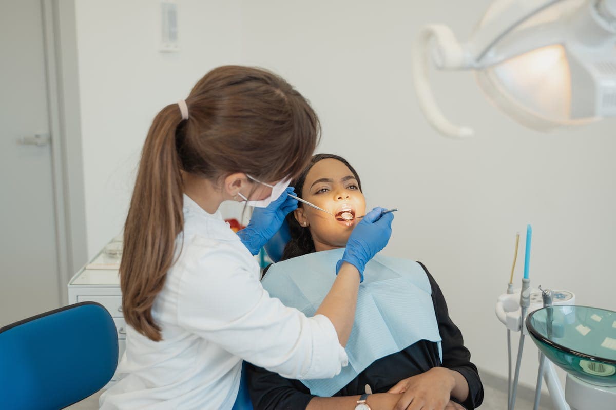 Woman in White Long Sleeve Shirt Checking the Teeth