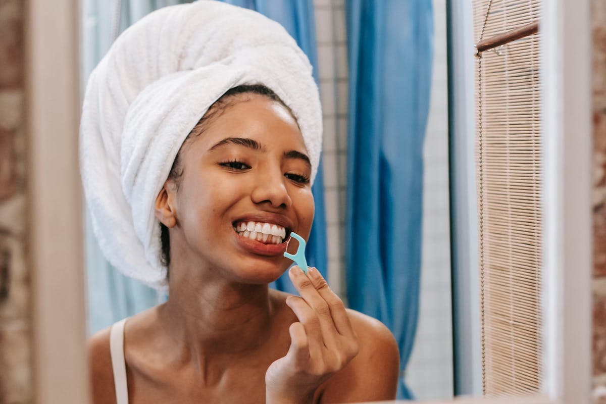 woman cleaning teeth with dental floss.jpg